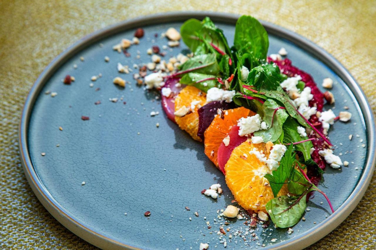 Steigenberger Hotel Herrenhof Vienna Exterior photo The photo shows a beautifully arranged plate of salad. It features vibrant slices of orange and a variety of greens, including spinach. There are also segments of beets, adding a pop of color. Crumbled white cheese is sprinkled on top, along with sma